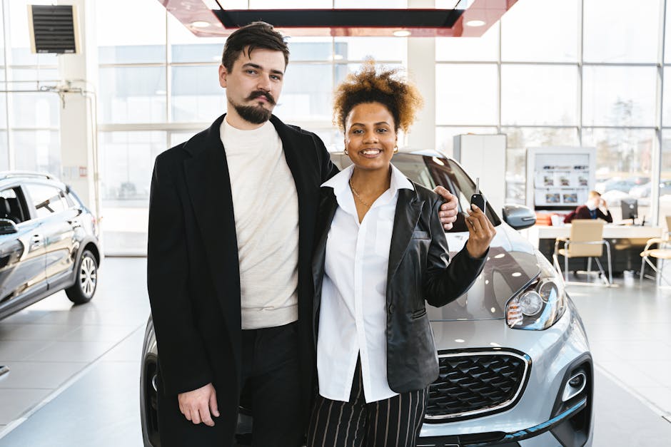 Interracial couple celebrates buying a new car at a dealership